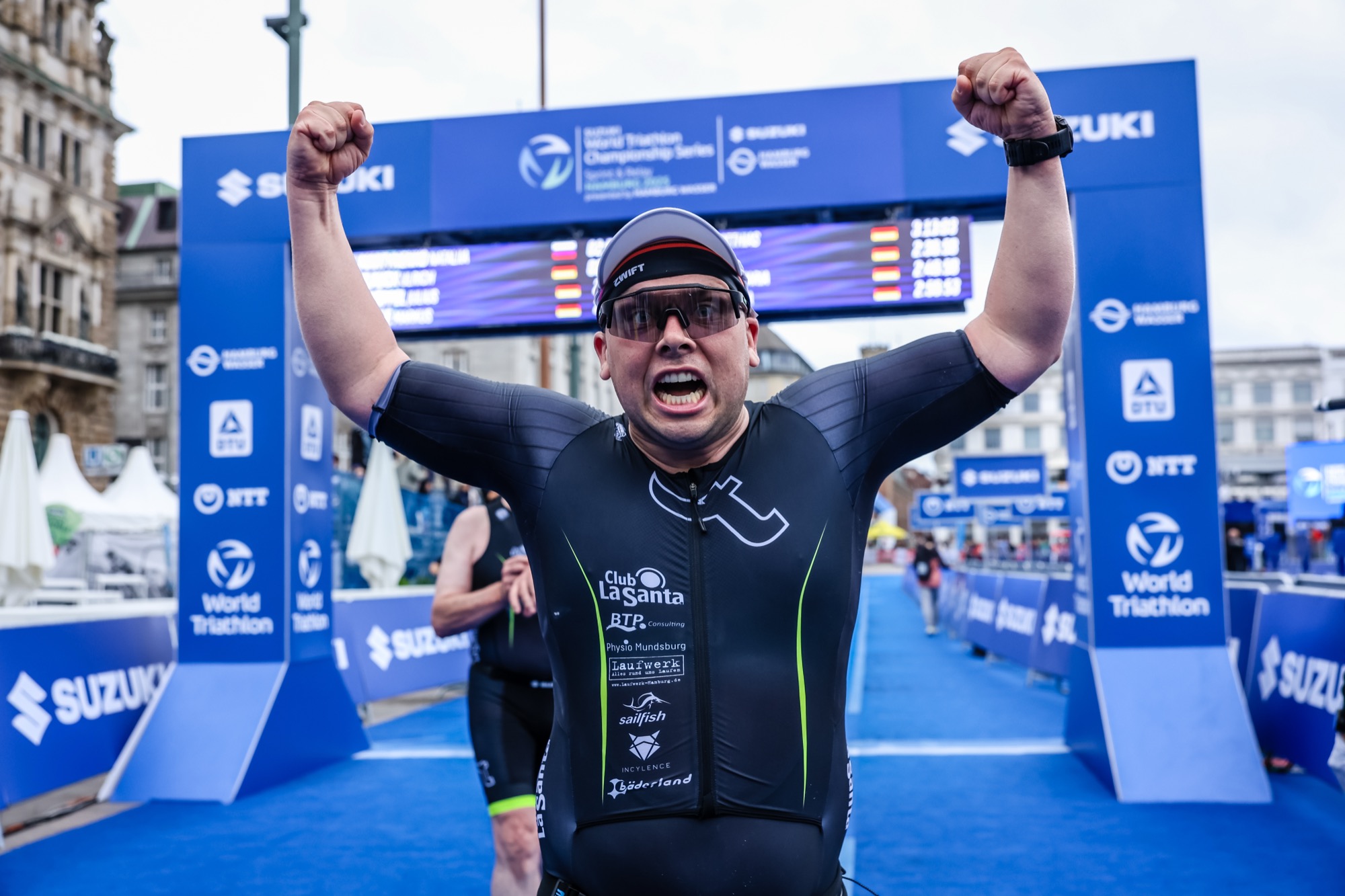 Triathlet jubelt im Ziel am Finisher-Bogen
